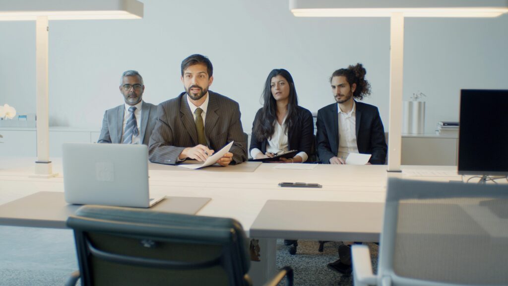 A diverse team in a business meeting using video conference in a modern office setting.